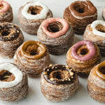 Load image into Gallery viewer, Set of assorted cronut dessert pastry topped with dulce de leche, tiramisu, vanilla, strawberry, hazelnut, and mixed berry icing. 

