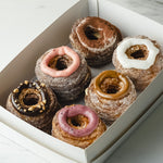 Load image into Gallery viewer, 6 piece box of assorted cronut dessert pastry topped with dulce de leche, tiramisu, vanilla, strawberry, hazelnut,
